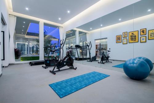 einen Fitnessraum mit Laufbändern und Trainingsgeräten in einem Haus in der Unterkunft No Flowers Boutique Hostel in Kunming