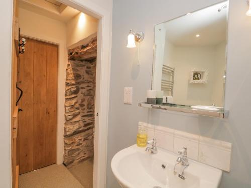une salle de bain avec un lavabo et un miroir dans l'établissement 1 Sunny Point Cottages, à Kendal