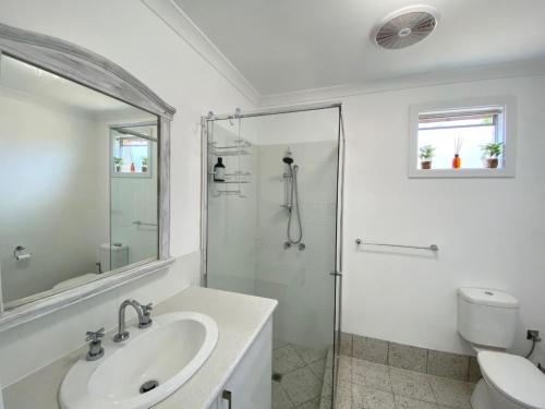 une salle de bain blanche avec une douche et un lavabo dans l'établissement Peppermint Cottage, à Broadwater