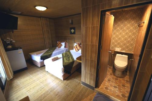a small room with two beds and a toilet at Thai Cozy House in Bangkok