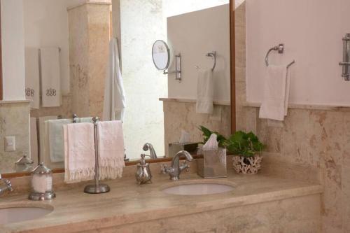 baño con 2 lavabos y espejo grande en Chic Luxury Condo At Los Altos Casa De Campo, en La Romana