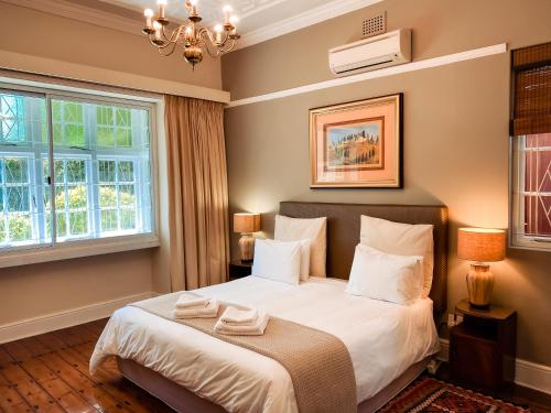 a bedroom with a bed and two windows at 5 Camp Street Guesthouse & Self-catering in Cape Town