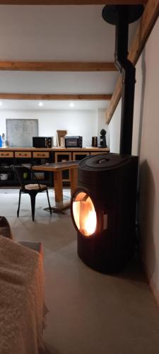 sala de estar con chimenea y escritorio en GITE BUCOLIQUE LES RONZIERES, en Saint-Paul-dʼUzore