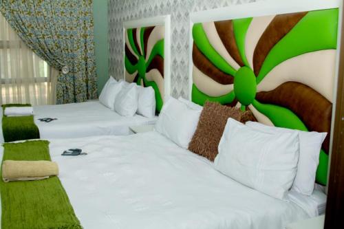 twee bedden in een hotelkamer met groen en wit bij Vakhusi Guesthouse in Malamulele