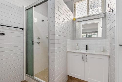 a bathroom with a shower and a sink and a mirror at Sea-Hi Beachside Apartment in Maroochydore