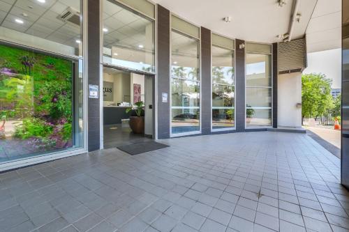 an empty lobby of a building with large glass doors at Argus Hotel Darwin in Darwin