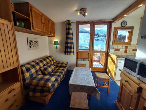 a living room with a couch and a table at Studio La Plagne, 1 pièce, 3 personnes - FR-1-351-64 in La Plagne