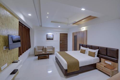 a bedroom with a bed and a tv in a room at Hotel City Inn in Gandhinagar