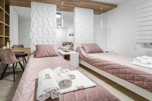 1 dormitorio con 2 camas y toallas. en Vila Cander en Kladovo