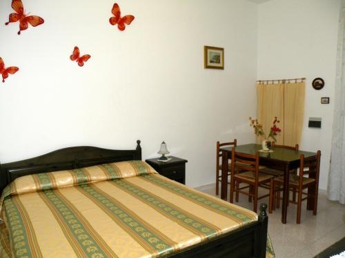 リーパリにあるAppartamenti Holiday Housing Lipari Centroのベッドルーム1室(ベッド1台付)が備わります。壁に蝶が飾られています。