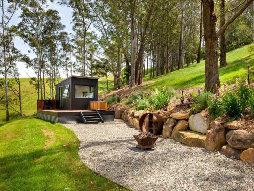 a cabin in the middle of a garden at Burroo at Kangaroo Valley I Perfect Views I Outdoor Bath in Barrengarry