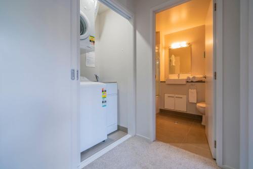 a bathroom with a sink and a toilet and a mirror at Hosts on the Coast Delight by the Pier in Whitianga