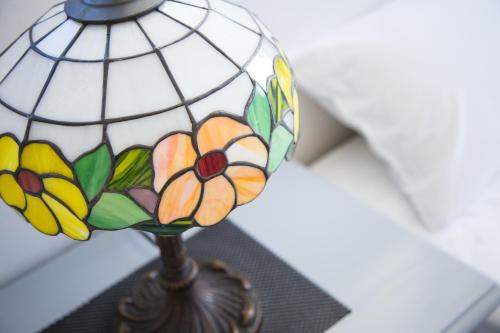 a glass lamp with flowers on it sitting on a table at パークサイドモリ in Motobu