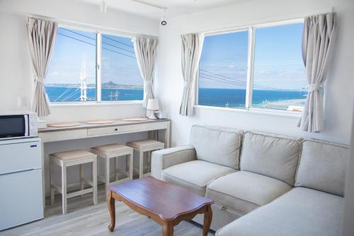 a living room with a couch and a table at パークサイドモリ in Motobu