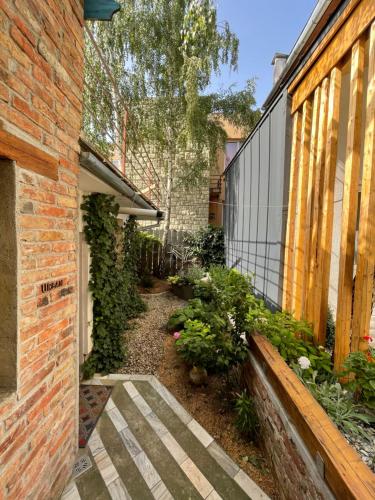 a garden with a brick building and a walkway at Apartament Art Cluj in Cluj-Napoca