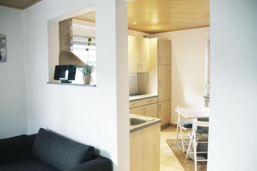 ein Wohnzimmer mit einem Sofa und einer Küche in der Unterkunft Feriennest Hüttenberg in Hochelheim