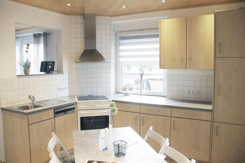 eine Küche mit einem Tisch, Stühlen und einem Waschbecken in der Unterkunft Feriennest Hüttenberg in Hochelheim