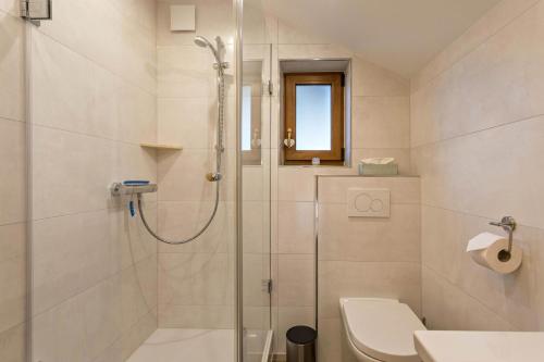 La salle de bains est pourvue d'une douche, de toilettes et d'un lavabo. dans l'établissement Ferienwohnung Rubin, à Mittenwald