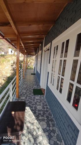 a porch of a house with a wooden roof at Saanidhya Sunset View Villa in Mukteswar