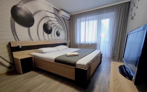 1 dormitorio con 1 cama y TV. en Двухкомнатные апартаменты центр Mystetsʹka 3 KR Apartments, en Krivoy Rog