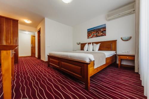 a hotel room with a large bed and a red carpet at Boutique Damiani in Sibiu
