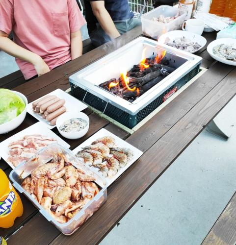 a picnic table with a grill with shrimp and other foods at 渡 - Duo Okinawa in Onna