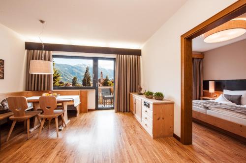 パルチーネスにあるAppartmenthotel Siegiのベッドルーム(テーブル、ベッド1台付)、ダイニングルームが備わります。