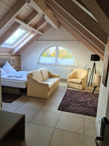 a bedroom with a bed and two chairs in a room at Avalon Hotel Bellevue in Fehmarn