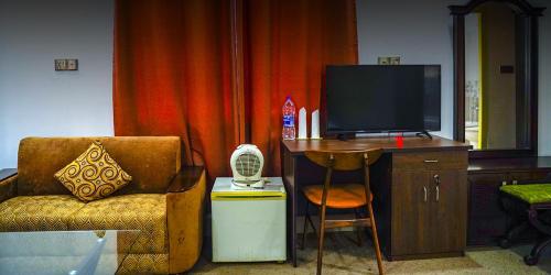 a living room with a chair and a television at Eque Heritage Hotel & Resort in Lakshmanpur Bālāpāra