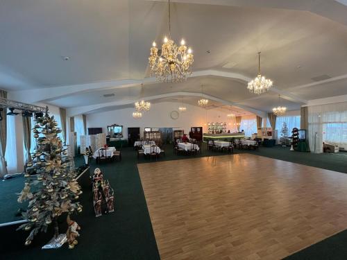 a large room with a christmas tree and chandeliers at Conacul Domnesc in Suceava