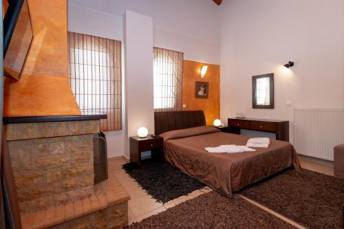 a bedroom with a bed and a fireplace at Ahilion Hotel in Kalavrita