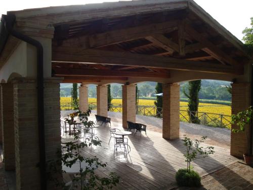 a patio with tables and chairs under a pavilion at Rustico del Conero in Camerano