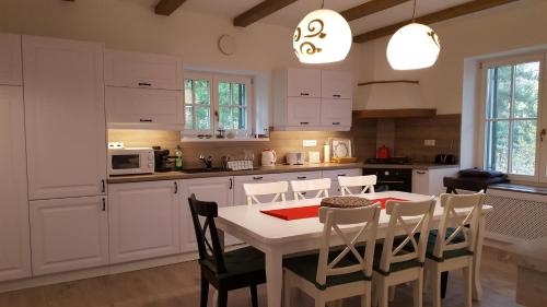 a kitchen with a white table and chairs in a room at Edit Villa in Matrafured