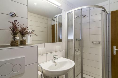 a white bathroom with a sink and a shower at Schwarzwaldmädel-Ferienwohnungen in Todtnau