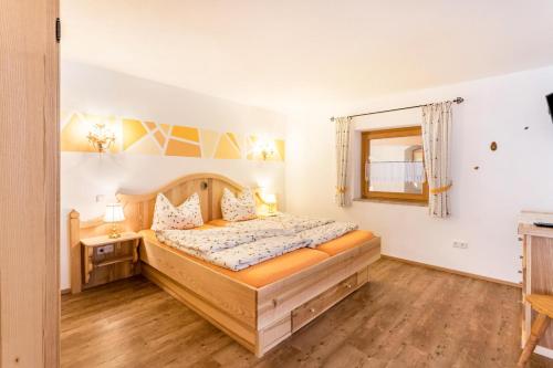 ein Schlafzimmer mit einem Holzbett und einem Fenster in der Unterkunft Ferienwohnung Bernstein in Mittenwald