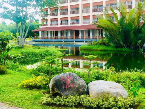 美娜多NDC Resort & Spa的建筑物前有池塘的建筑物