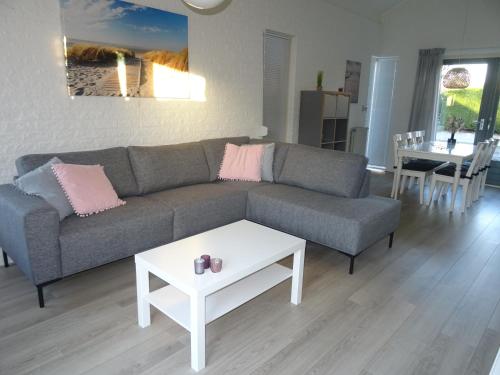 a living room with a couch and a table at Kustverhuur, Park Schoneveld, Strandparel 357 in Breskens