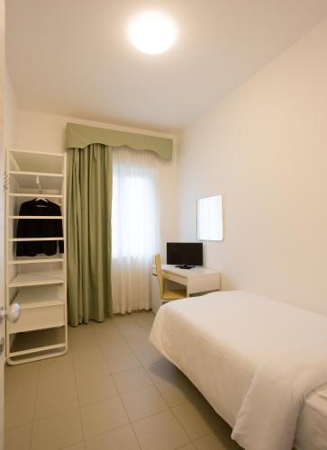 a bedroom with a bed and a desk with a computer at Villa Nazareth Fermo in Fermo
