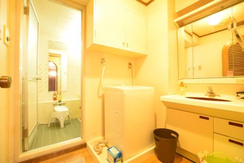 uma casa de banho com um chuveiro, um lavatório e um WC. em Matoba 6F in Dotonbori em Osaka