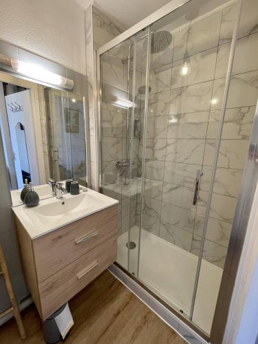 La salle de bains est pourvue d'un lavabo et d'une douche. dans l'établissement Ma Location Sablaise - Appart' Le Chenal, à Les Sables-dʼOlonne