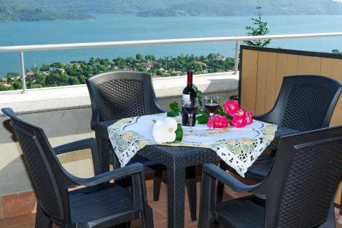 a table with wine glasses and flowers on a balcony at Residence Le Azalee & SPA in Vercana