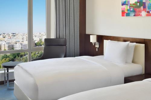 a hotel room with two beds and a window at Mövenpick Hotel Amman in Amman