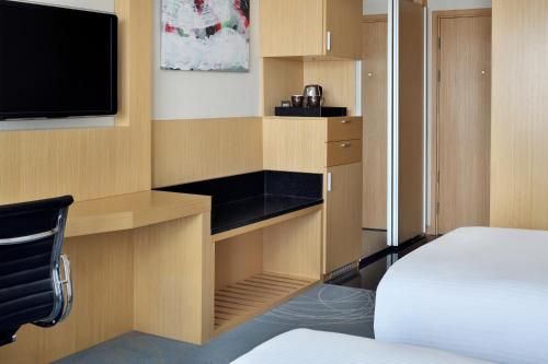 a room with a bed and a tv in a room at Mövenpick Hotel Amman in Amman