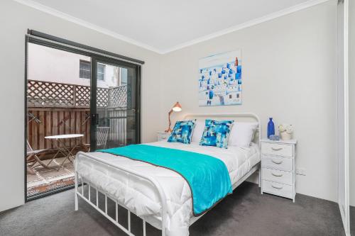 Habitación blanca con cama y ventana en Spacious & Charming Alexandria 2 Bdrm Apartment - Secured Parking Space, en Sídney