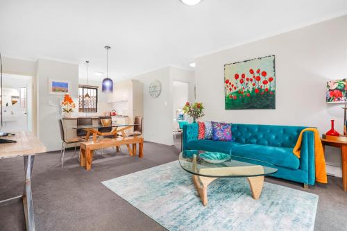 sala de estar con sofá azul y mesa en Spacious & Charming Alexandria 2 Bdrm Apartment - Secured Parking Space, en Sídney