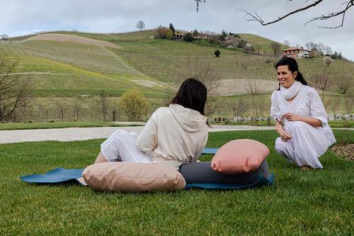 two women sitting on the grass in the grass at L'aja della Mirusina - Piedmont Resort Monferrato Langhe in Canelli