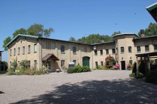 a large brick building with a large driveway at Ferienwohnung Innenhof in Pommerby