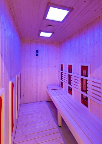 a room with benches in a pink room at Hunguest Hotel Panoráma in Hévíz