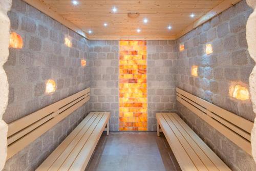 a row of benches in a room with a brick wall at Hunguest Hotel Panoráma in Hévíz