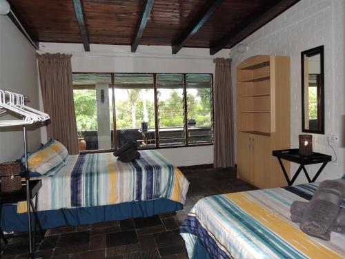 a bedroom with two beds and a large window at Bushpigs Haven in St Lucia
